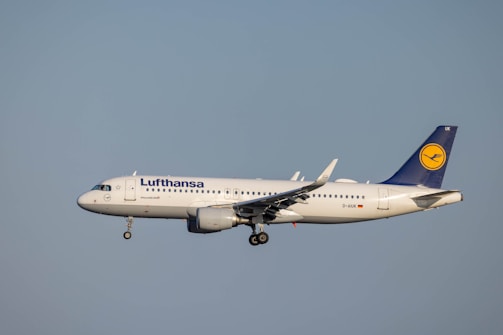 A close-up shot of a Lufthansa airplane taking off at Munich Airport during golden hour.