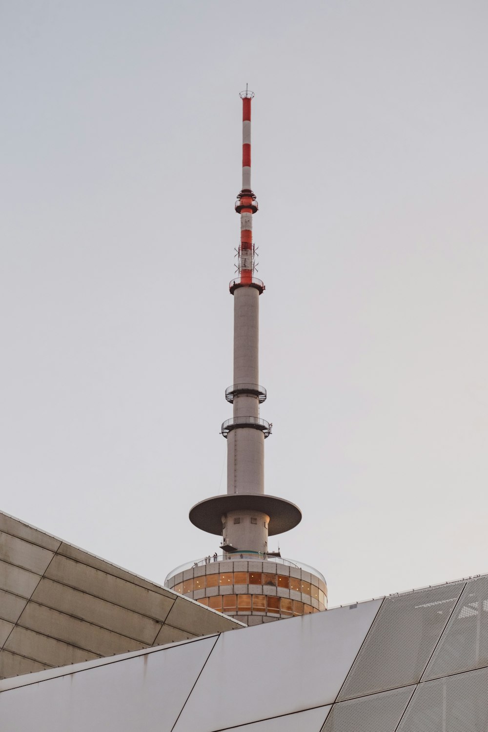 a tall tower with a red and white flag on top of it