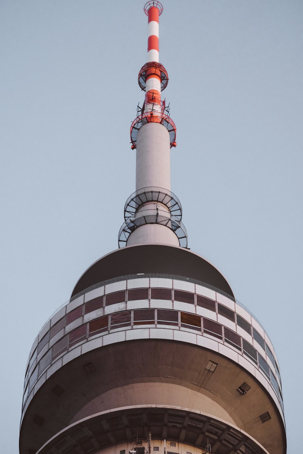 the top of a building with a red and white tower
