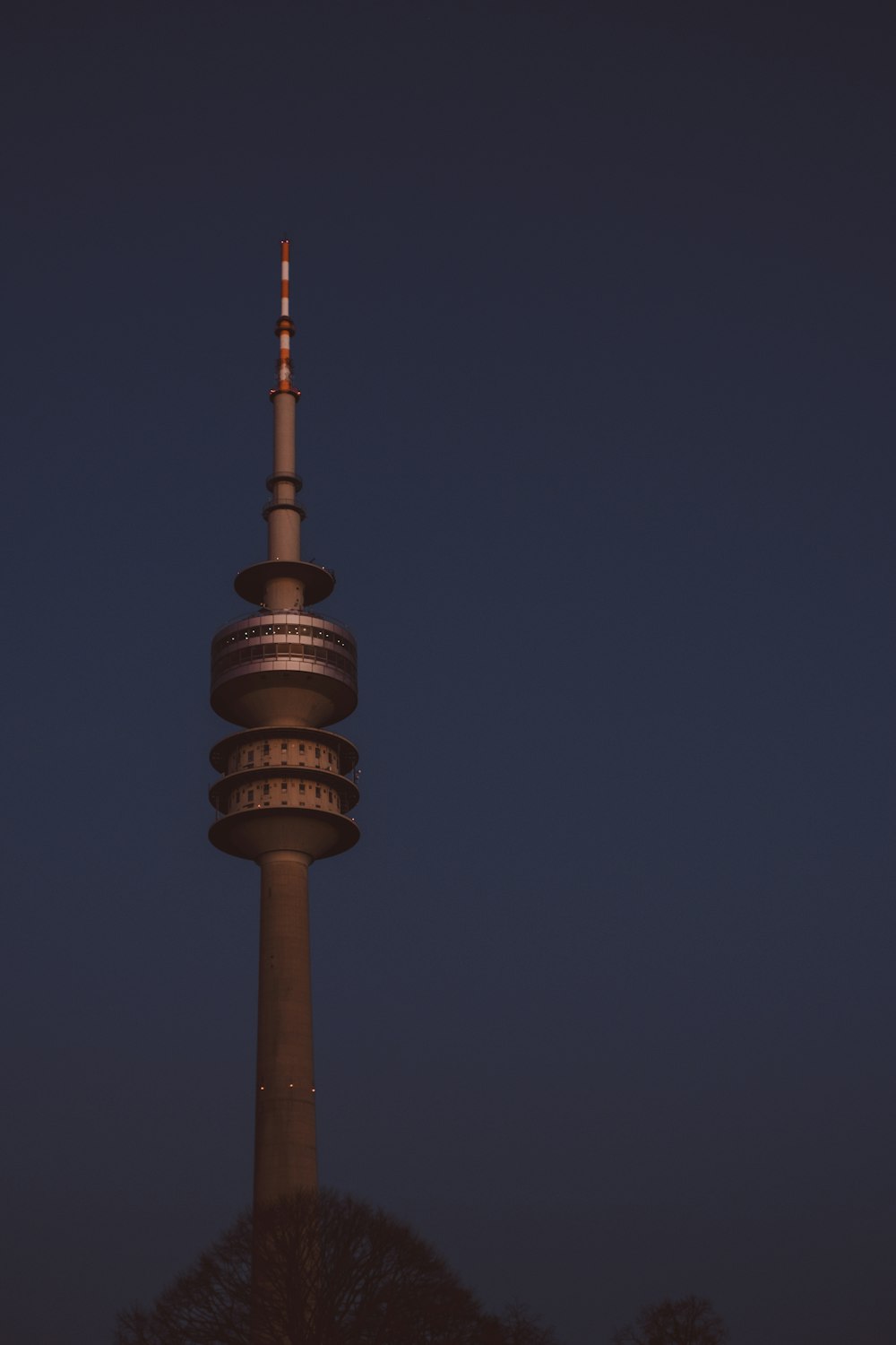 a very tall tower with a very tall clock on it's side