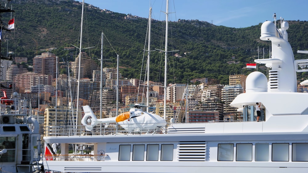 a large white boat in a harbor with a city in the background