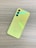 A yellow smartphone is placed face down on a wood grain textured surface, featuring three camera lenses and a subtle Samsung logo near the bottom.