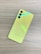 A yellow smartphone is placed face down on a wood grain textured surface, featuring three camera lenses and a subtle Samsung logo near the bottom.