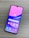 A smartphone with a colorful display featuring various app icons such as Store, Gallery, Google Play, and Google, is lying on a wooden surface. The screen has a gradient background of pink and purple shades.
