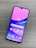 A smartphone with a colorful display featuring various app icons such as Store, Gallery, Google Play, and Google, is lying on a wooden surface. The screen has a gradient background of pink and purple shades.