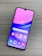 A smartphone with a colorful display featuring various app icons such as Store, Gallery, Google Play, and Google, is lying on a wooden surface. The screen has a gradient background of pink and purple shades.