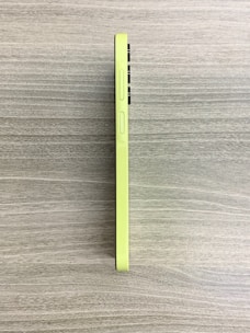 Close-up of a neon green and black phone case with a textured grip, resting on a modern desk.