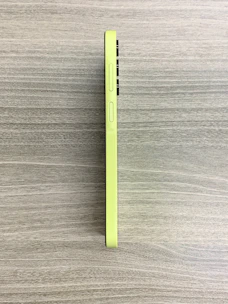 A sleek mobile phone displaying a clean, simple app interface glowing against a matte forest green background.