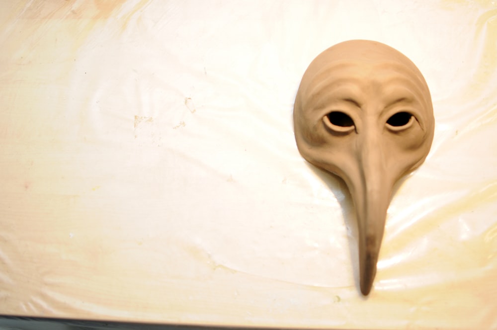 a mask with a long beak on a table