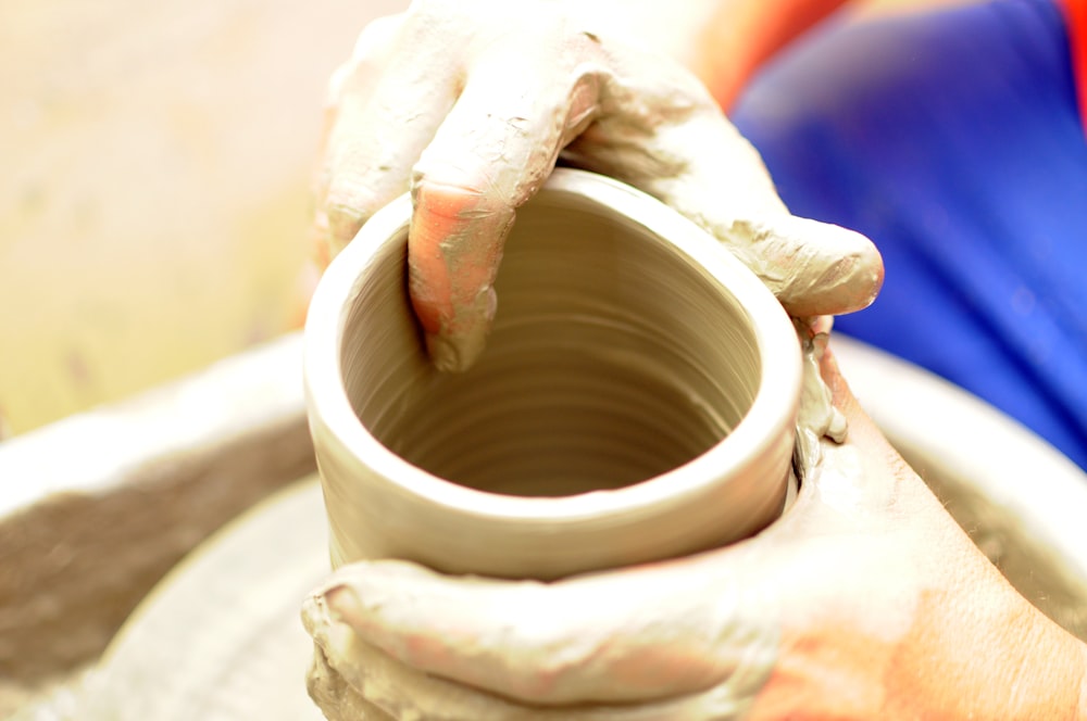 a person is making a pot on a potter's wheel