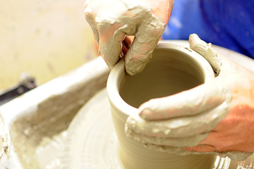 a person making a pot on a potter's wheel