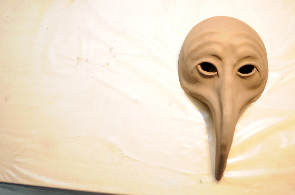 a mask with a long beak on a table