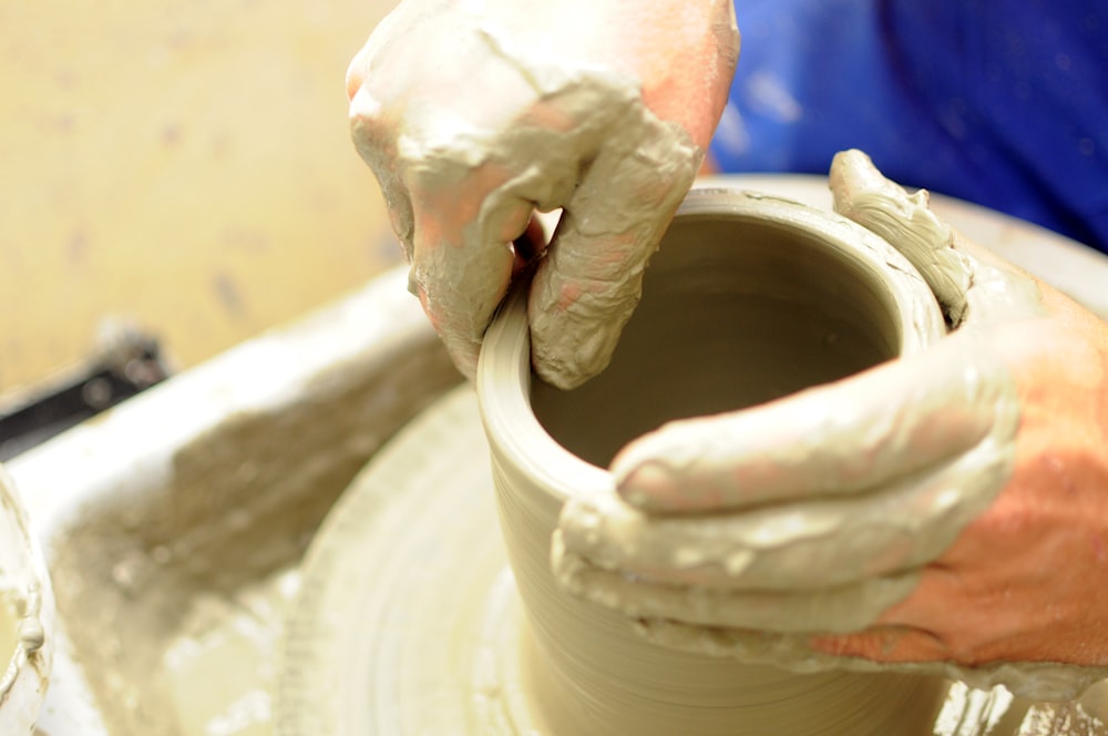 a person is making a pot on a potter's wheel