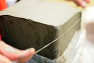 Hands inspecting the texture of a freshly molded ceramic block.