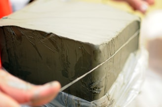 Instructor demonstrating slab-construction geometry with clay slabs and tools.