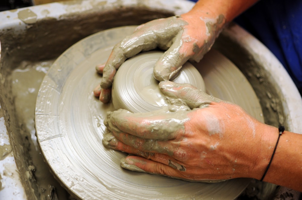 a person is making clay on a wheel