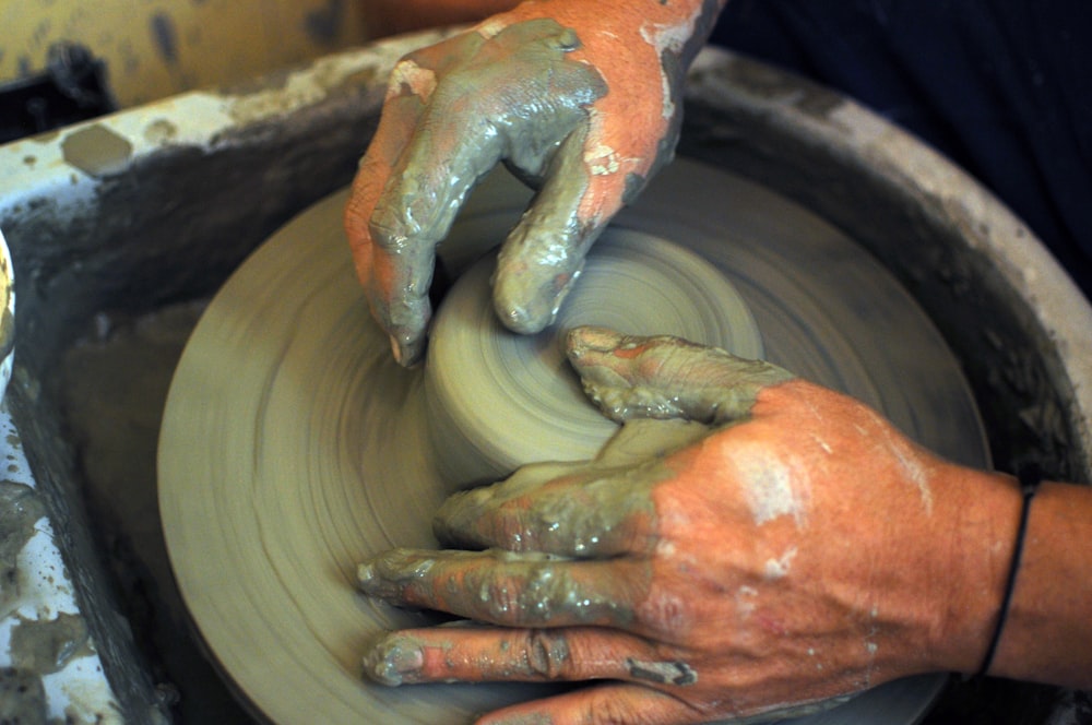 a person making a pot on a potter's wheel