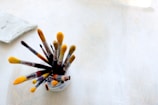 Close-up of colorful paintbrushes resting in a jar