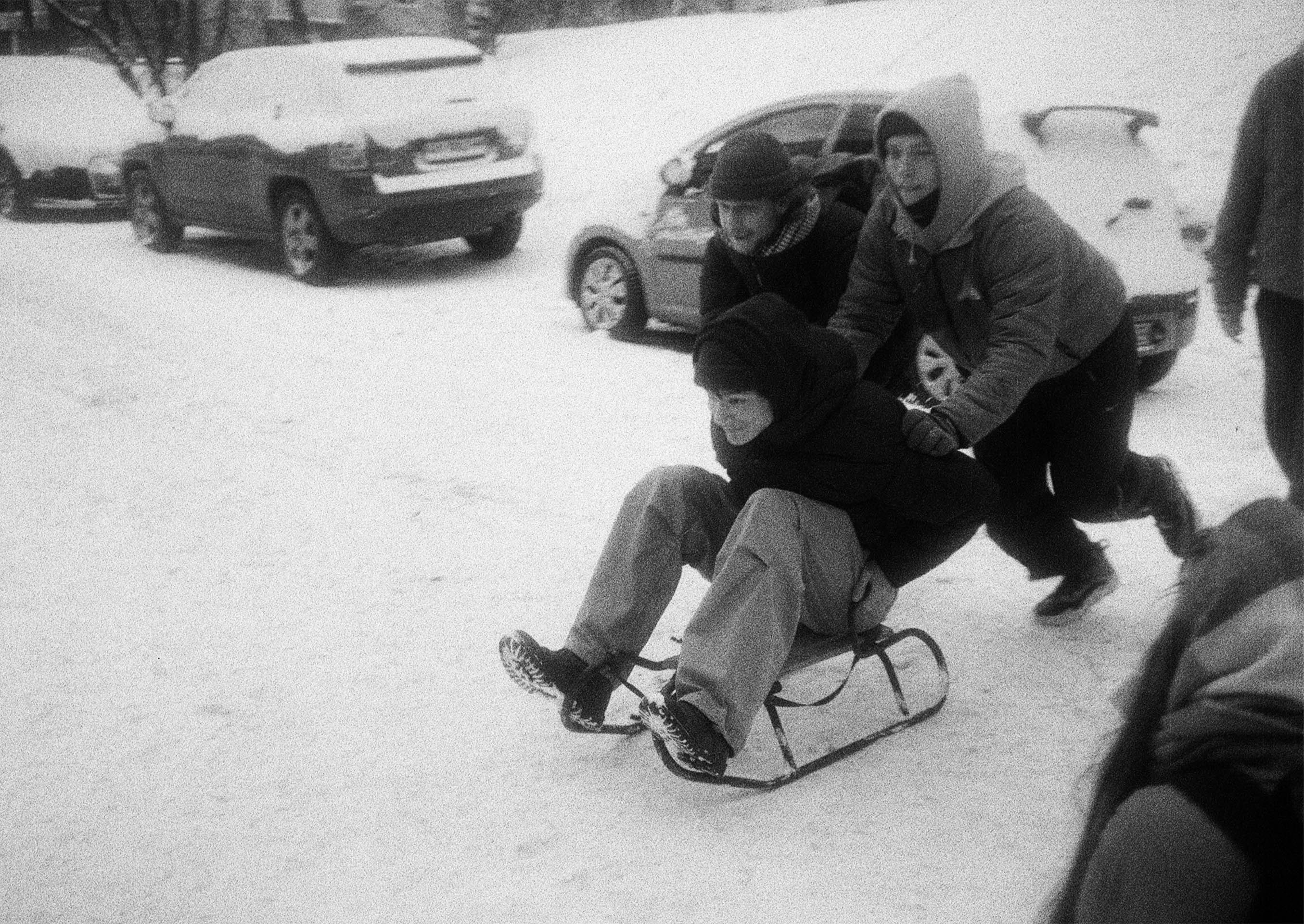 A man riding a sled down a snow covered street photo Free Men Image