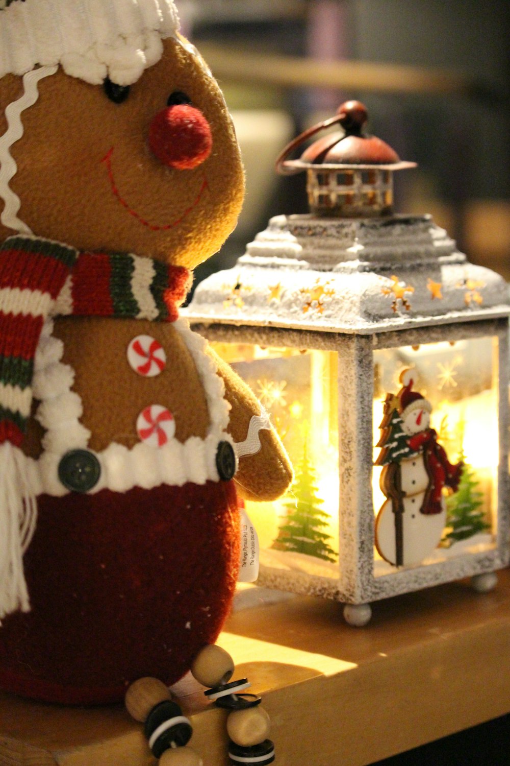 a gingerbread man sitting next to a lit lantern