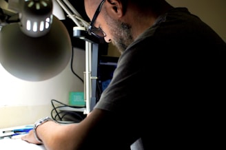 A calm, focused entrepreneur reviewing notes and plans, illuminated by soft desk lighting.