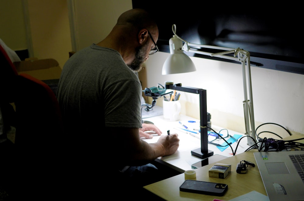 a man sitting at a desk writing on a piece of paper