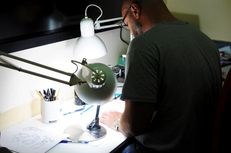 A designer working on branding sketches at a bright studio desk.