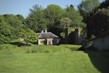 a house in the middle of a lush green field