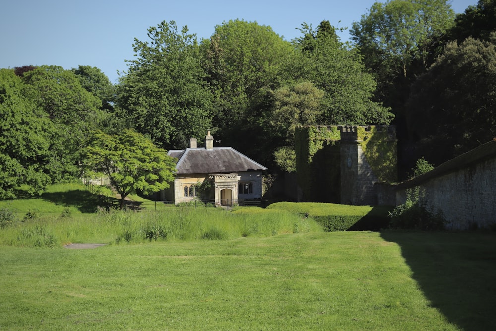 a house in the middle of a lush green field