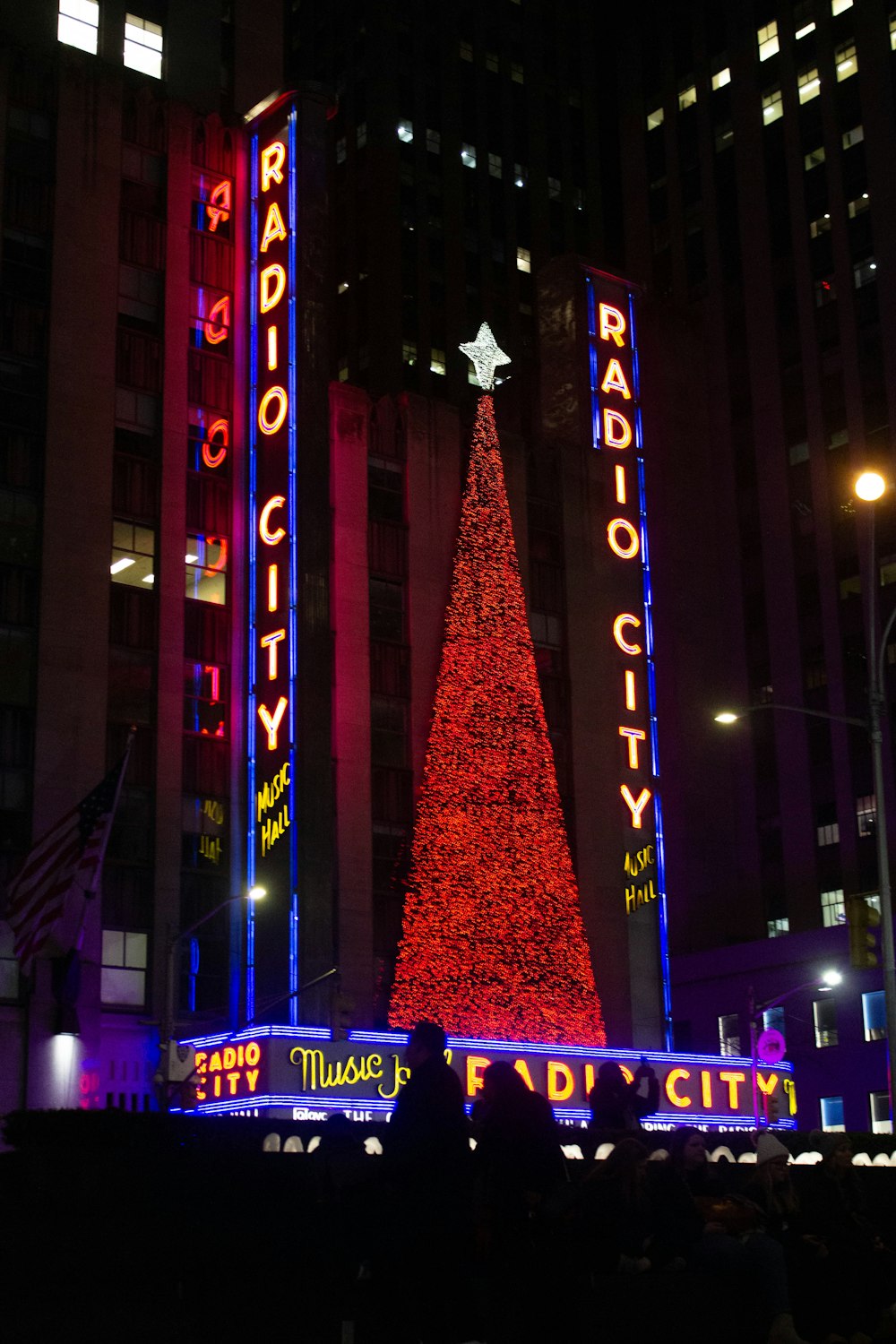 the radio city christmas tree is lit up at night