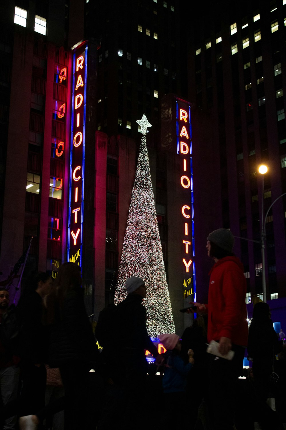 a christmas tree is lit in front of radio city radio city