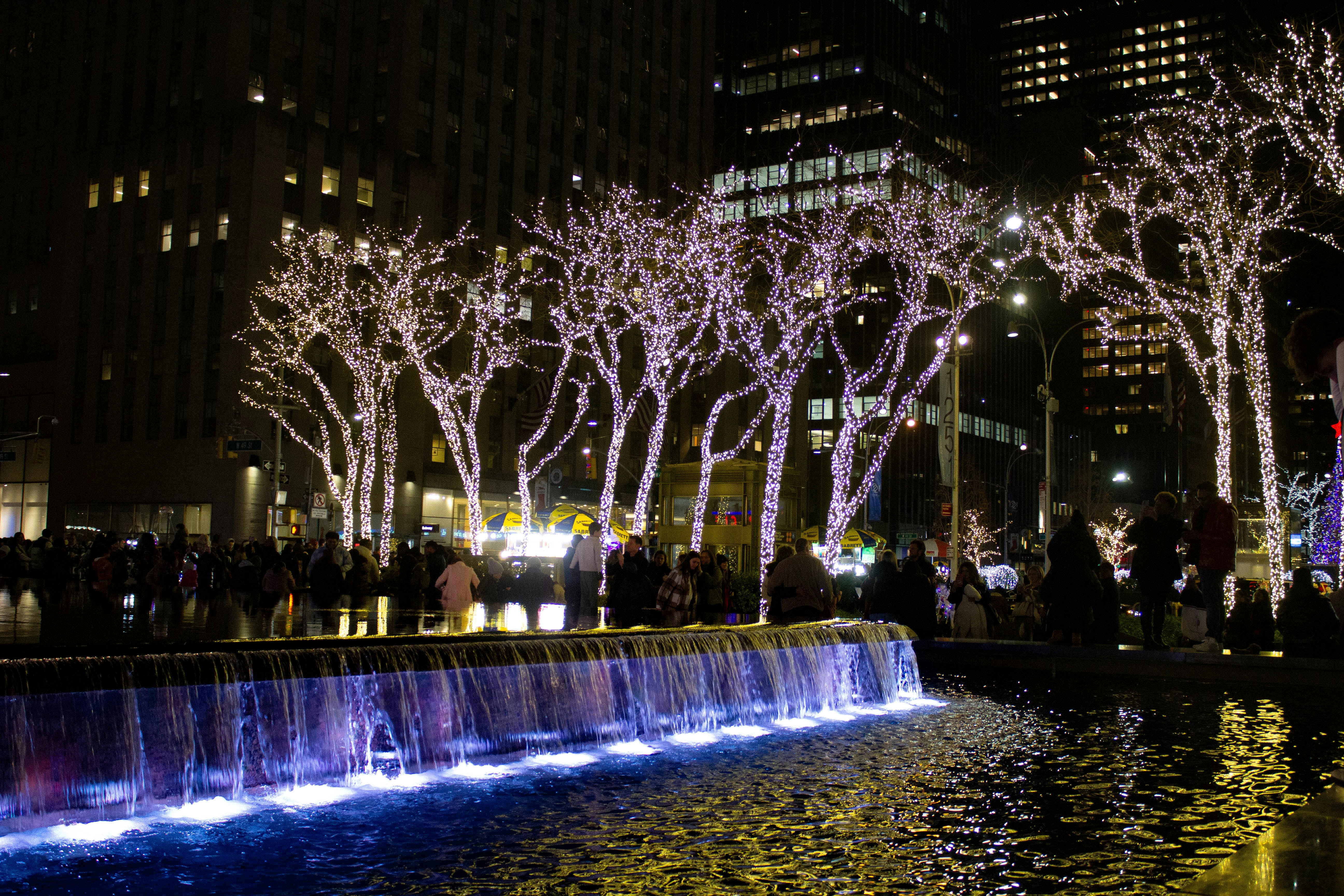 a group of people standing around a fountain