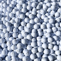 a pile of white golf balls sitting on top of each other