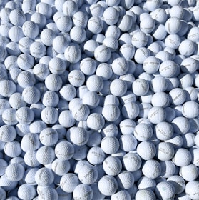 Golf balls marked with custom stencils arranged neatly on a wooden table.