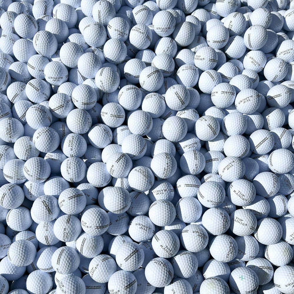 a pile of white golf balls sitting on top of each other
