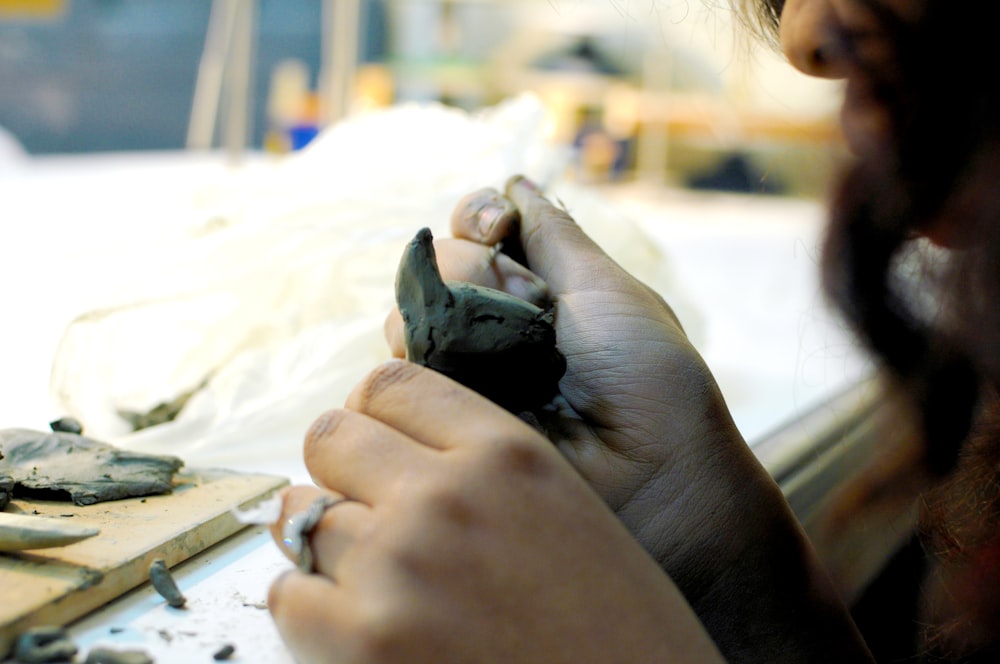a woman is working on a piece of pottery