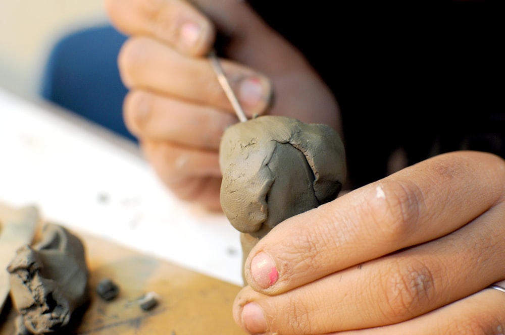 a person holding a piece of clay in their hands