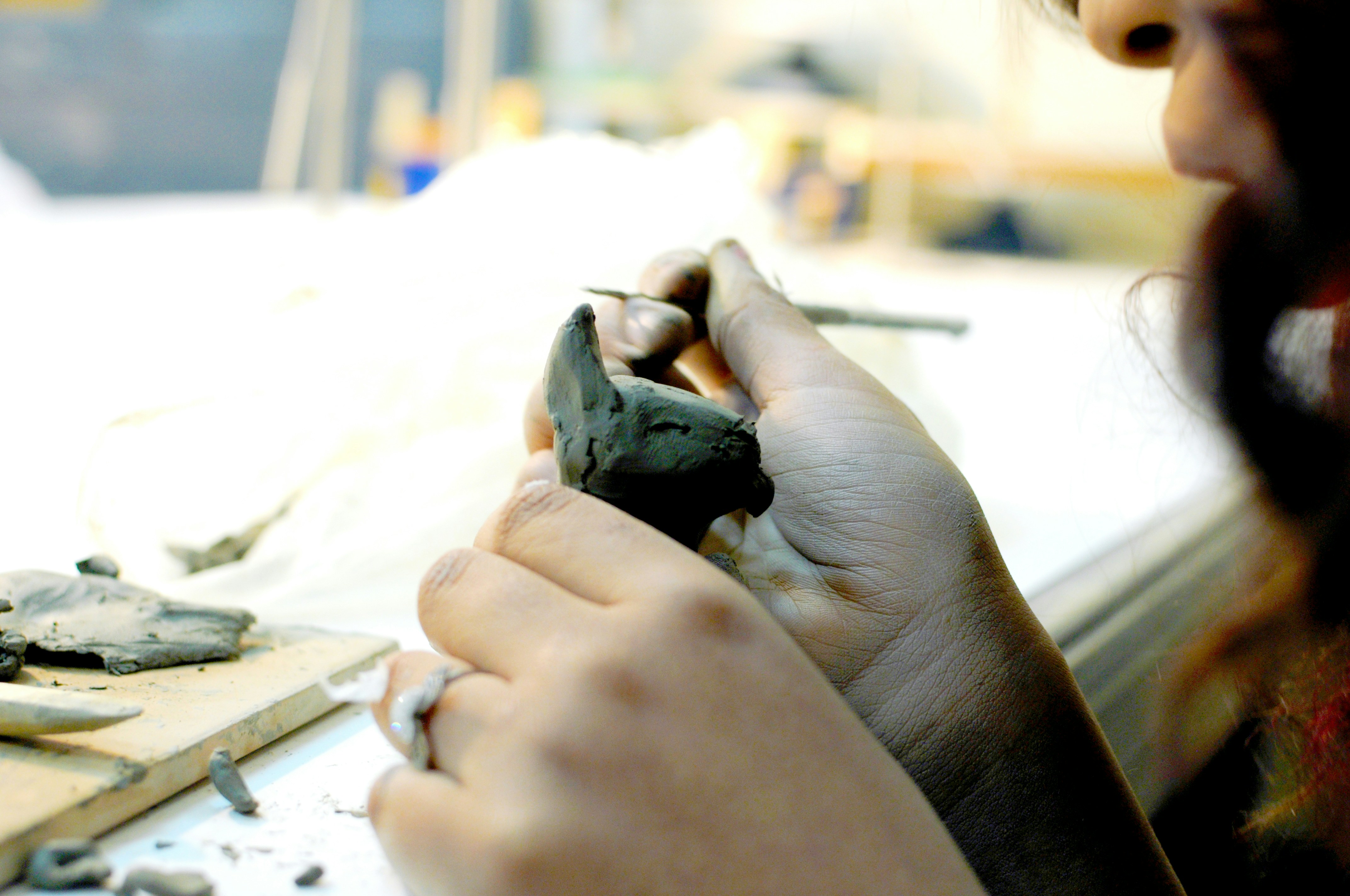 a woman is working on a piece of pottery