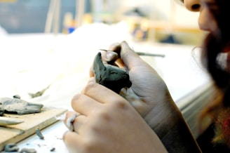 a woman is working on a piece of pottery