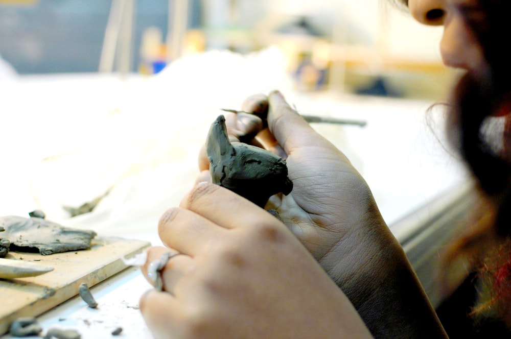 Une femme travaille sur un morceau de poterie