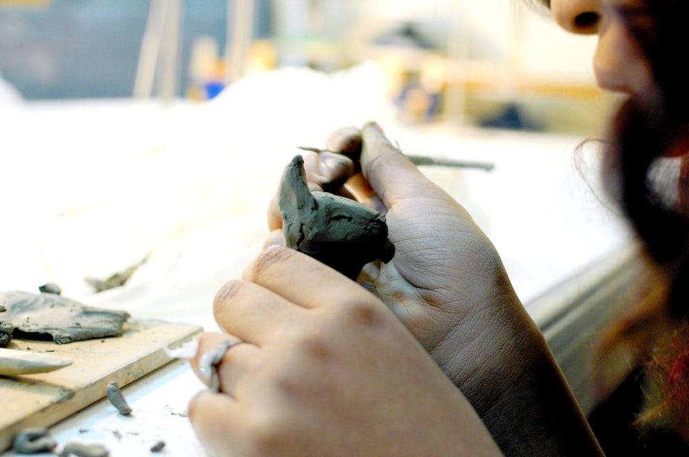 a woman is working on a piece of pottery