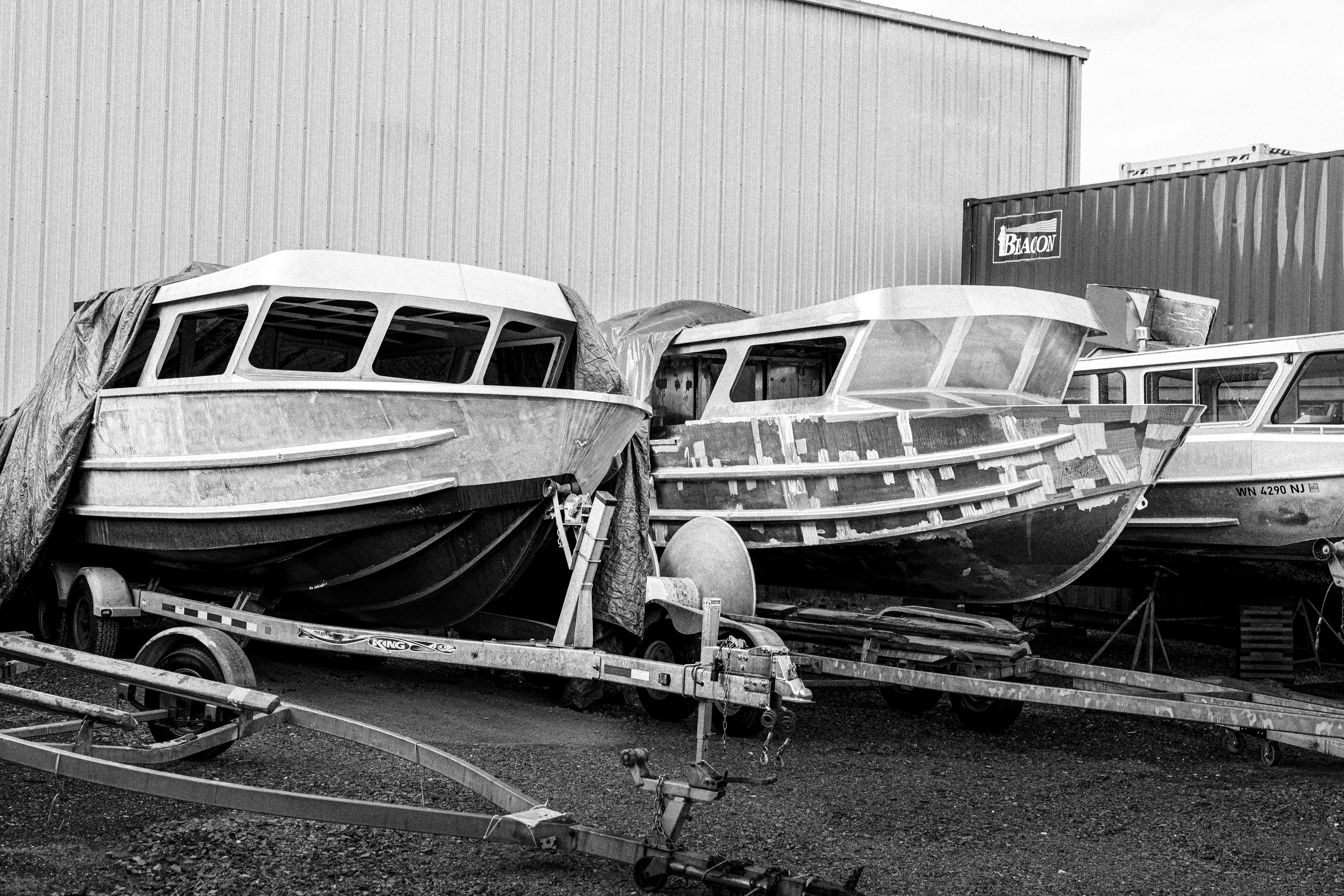a black and white photo of two boats on a trailer