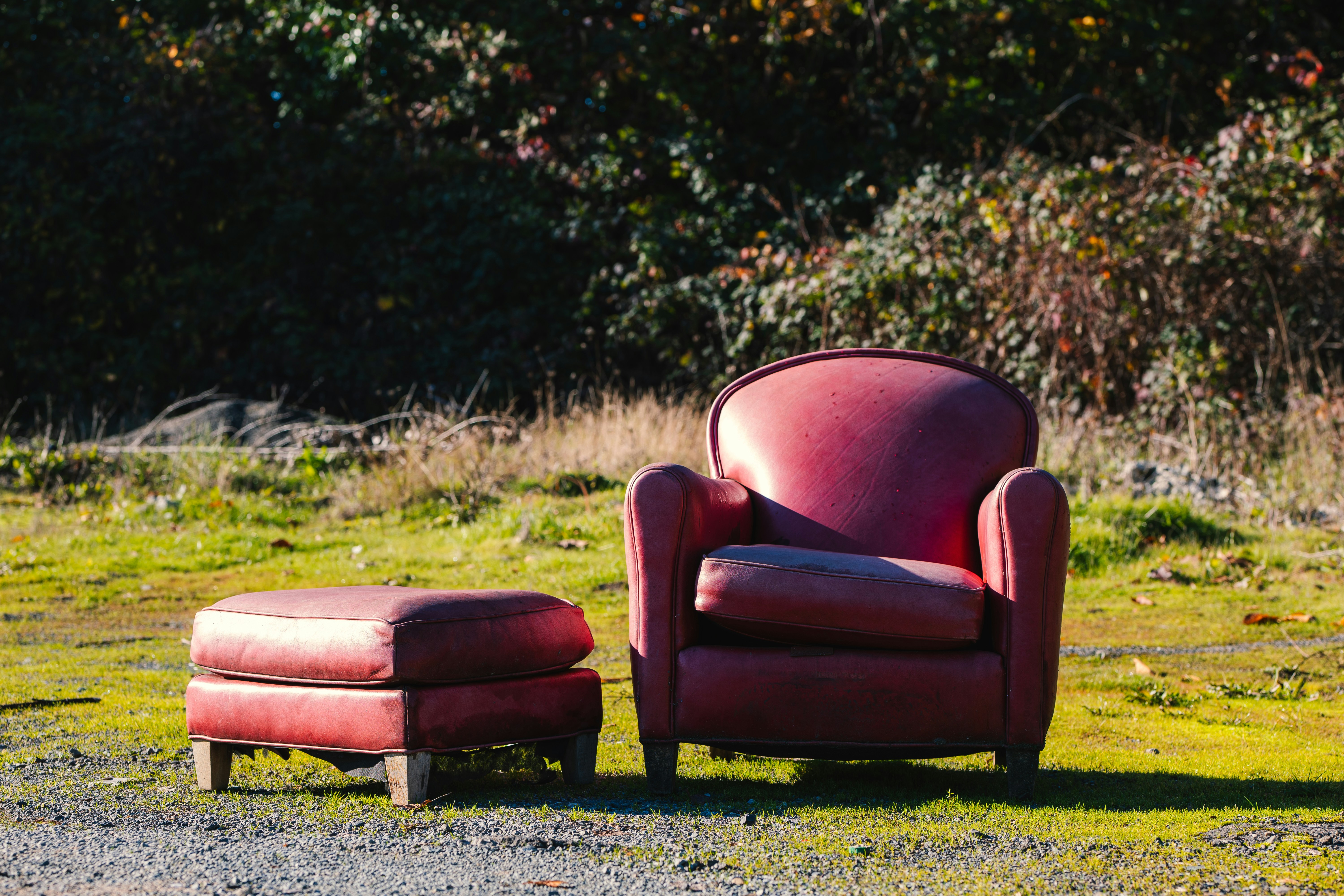 a red chair and ottoman sitting in the grass