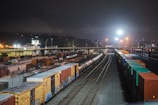 Nighttime shot of a cargo yard illuminated with activity and logistics operations.