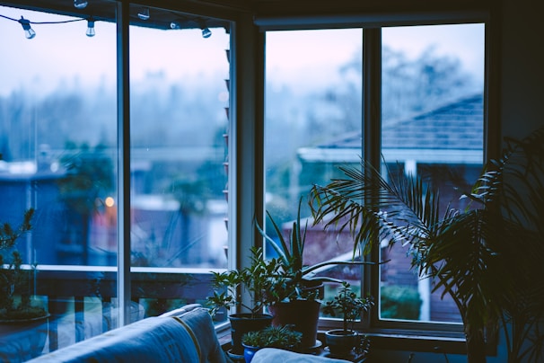 A bright, inviting living room filled with subtle mist from a sleek humidifier and fresh flowers on a wooden table.