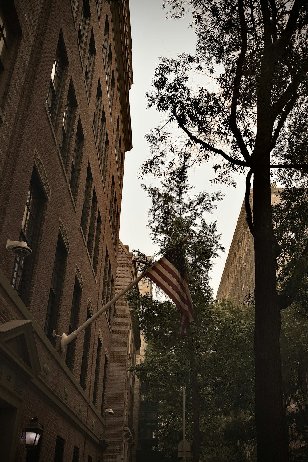 an american flag flying in front of a tall building