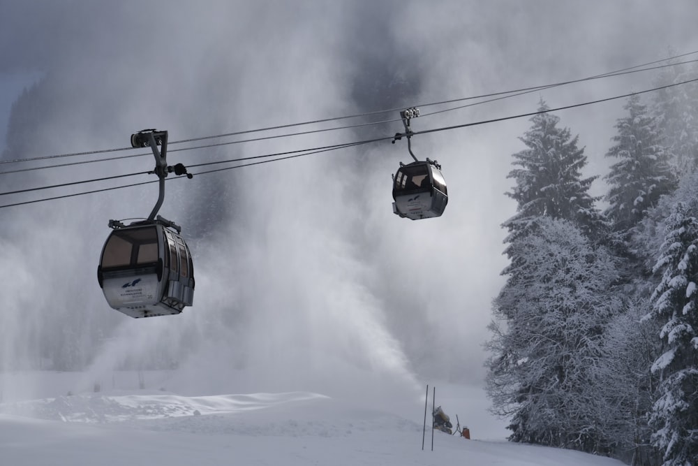 a ski lift with two people on it going up a snowy hill