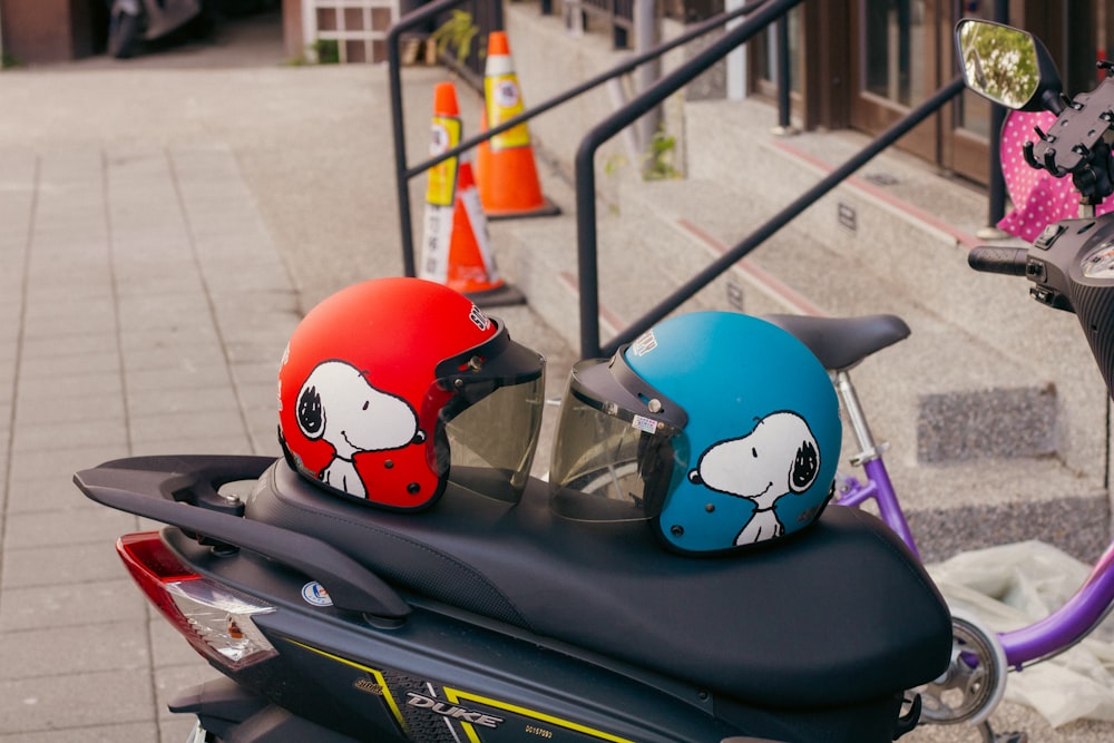 a couple of helmets sitting on the back of a scooter
