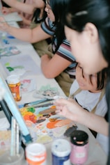 Participants painting and crafting together in a bright community room.