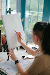 a woman is drawing on a white board
